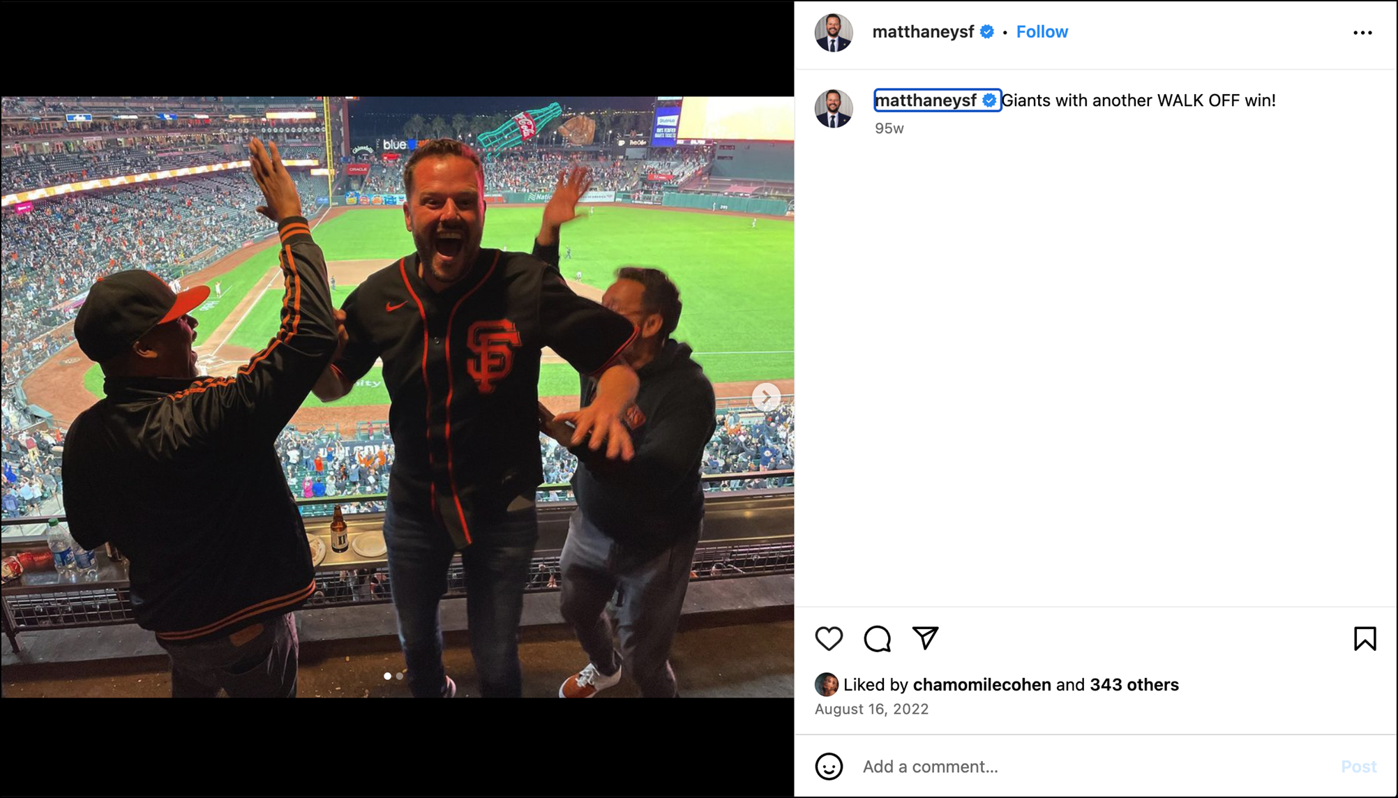 Three jubilant people wearing San Francisco Giants gear celebrate in a stadium suite overlooking a baseball field. The background shows a cheering crowd.