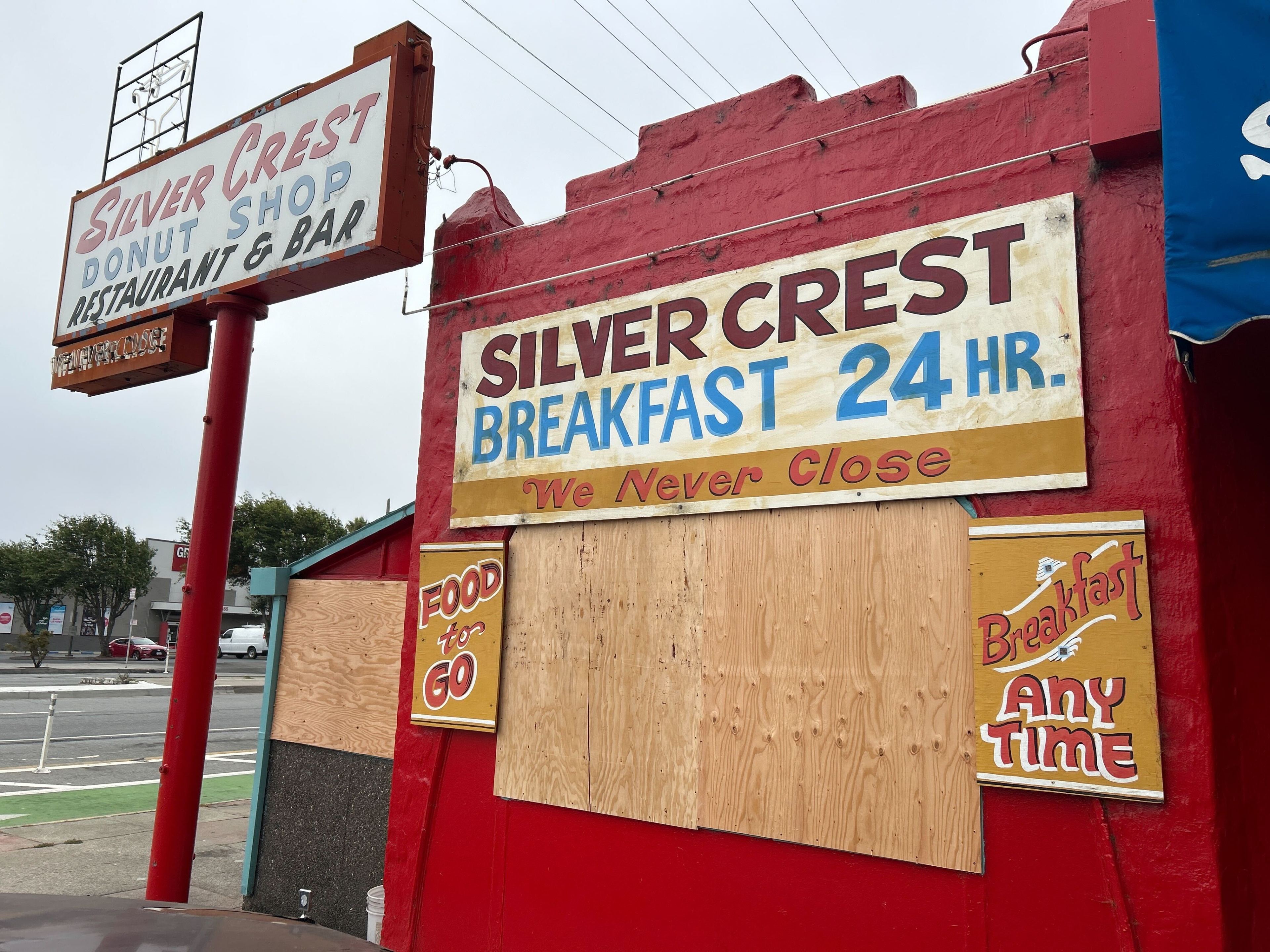 The image shows the Silver Crest Donut Shop, a red building with signs advertising 24-hour breakfast, food to go, and that they never close.