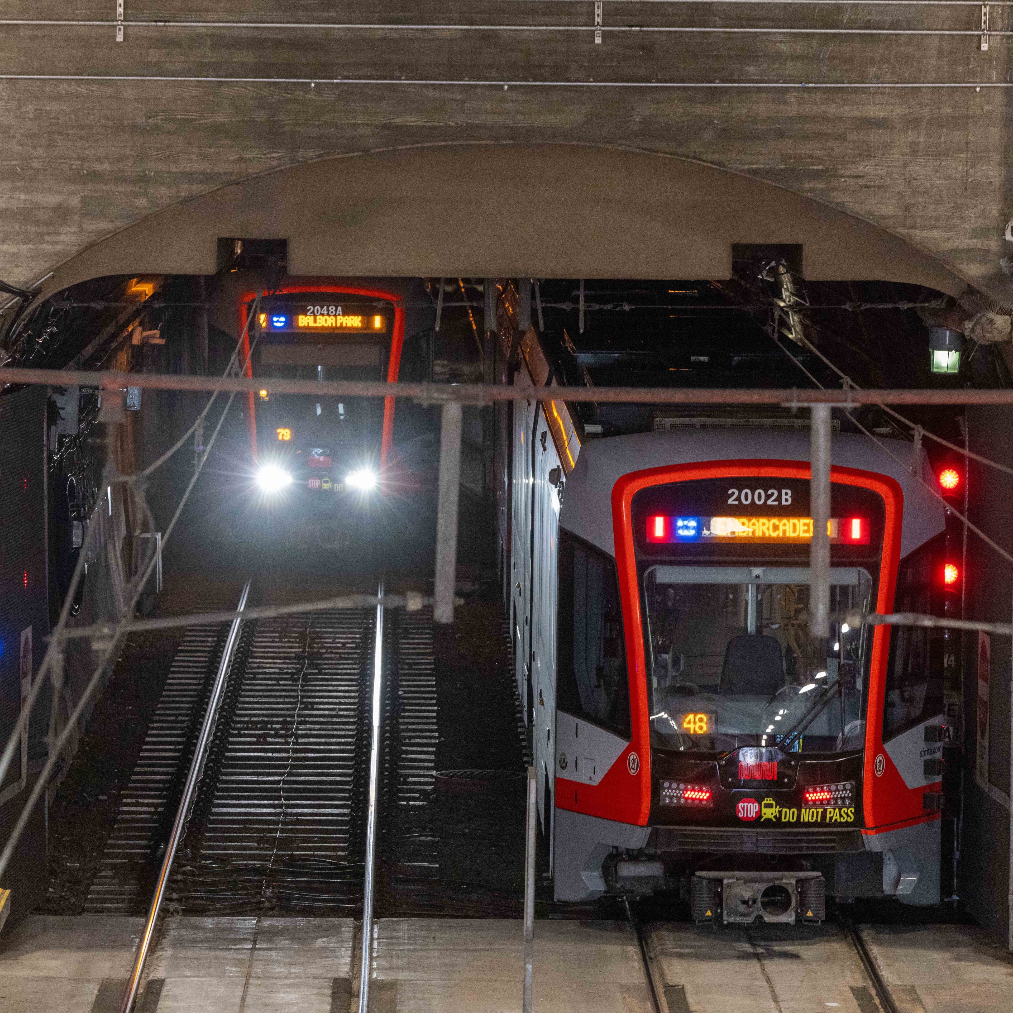 Two trains are approaching each other in a tunnel. One train is heading to "Balboa Park," while the other is en route to "Embarcadero."