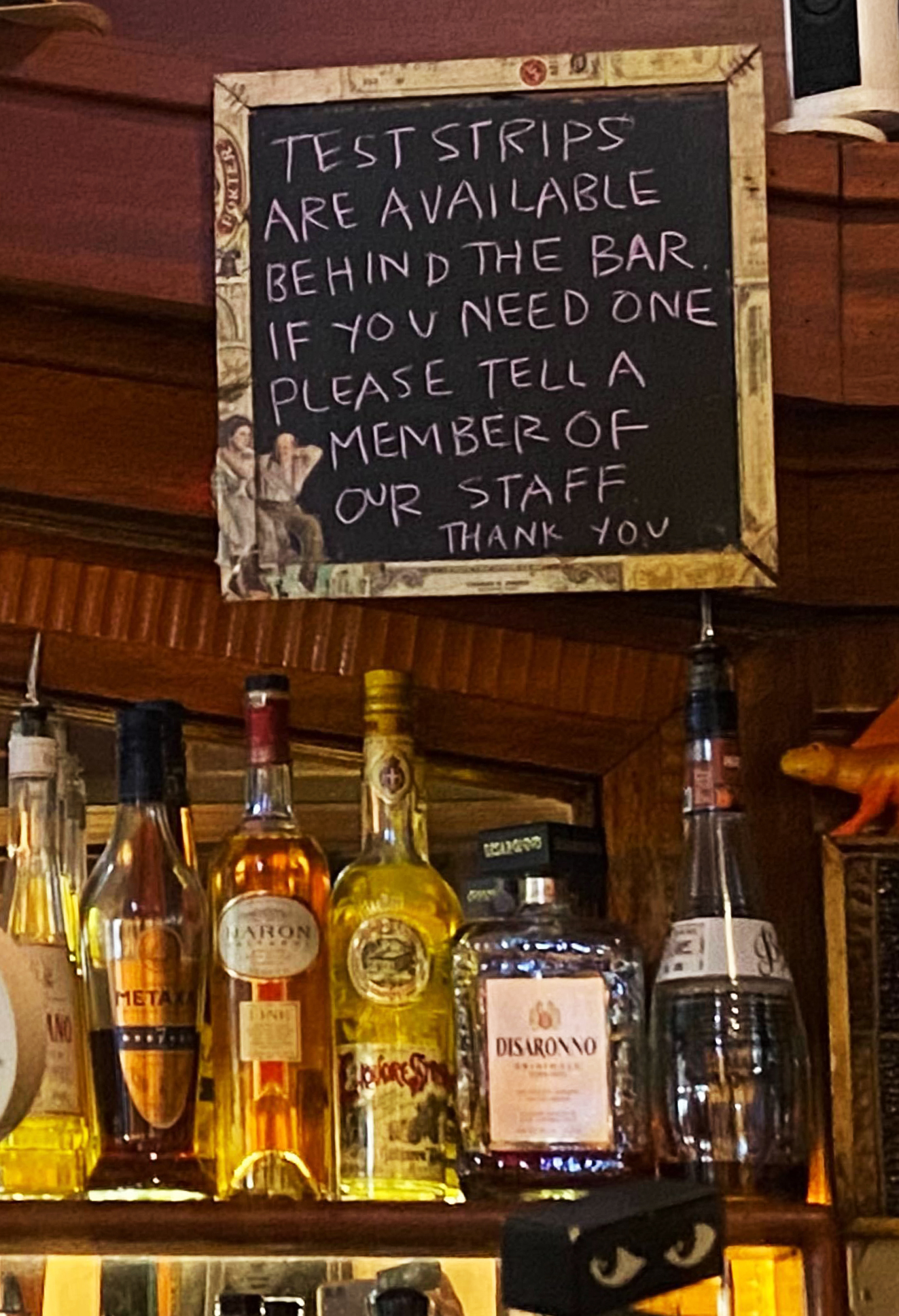 A sign above a bar reads: &quot;Test strips are available behind the bar. If you need one please tell a member of our staff. Thank you.&quot;