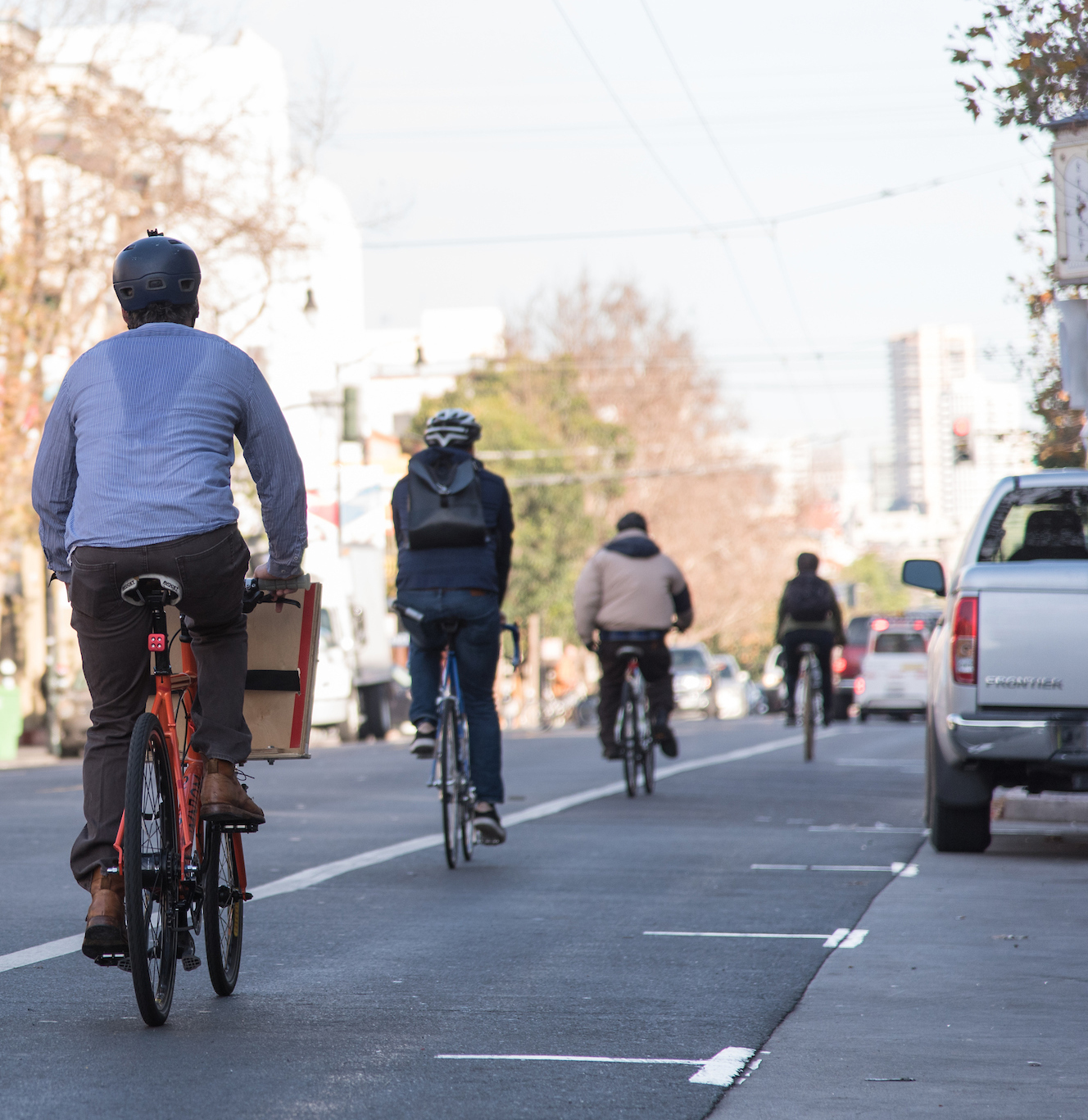 Cyclists ride down a city street.