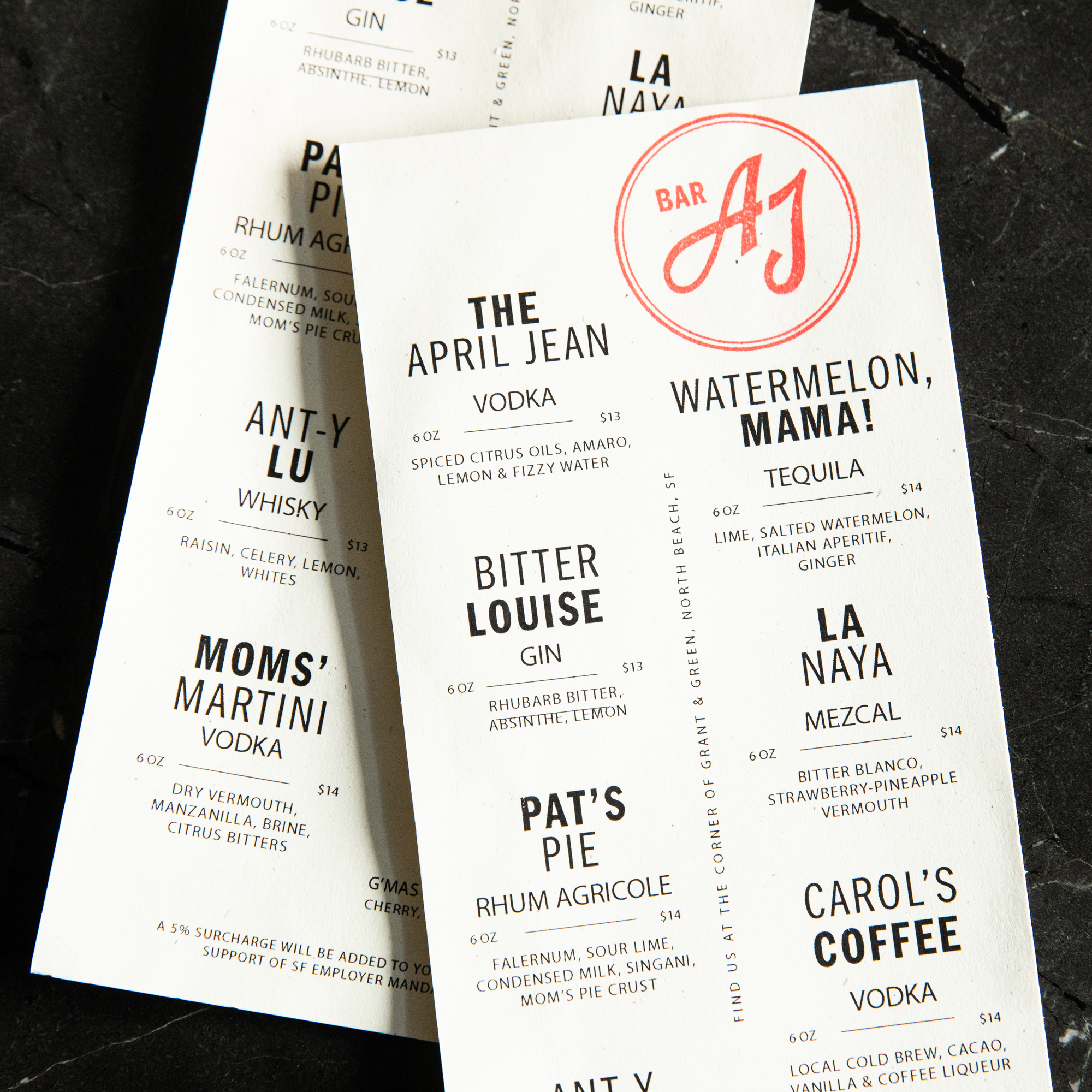 The image shows two overlapping cocktail menus listing various drinks with ingredients and prices, featuring names like &quot;The April Jean,&quot; &quot;Bitter Louise,&quot; and &quot;Pat's Pie.&quot;