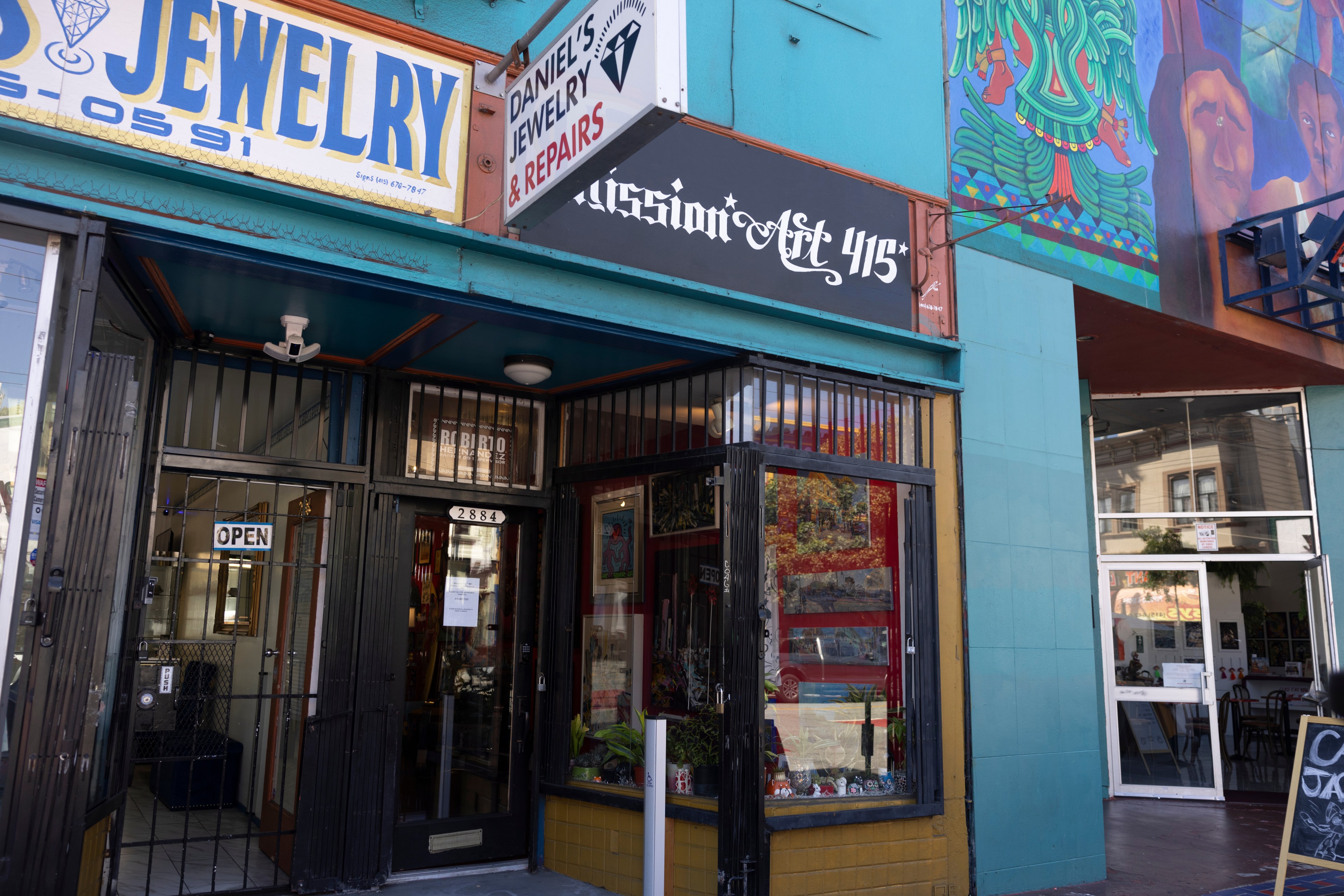 A small storefront called &quot;Mission Art 415&quot; sits in a blue building.