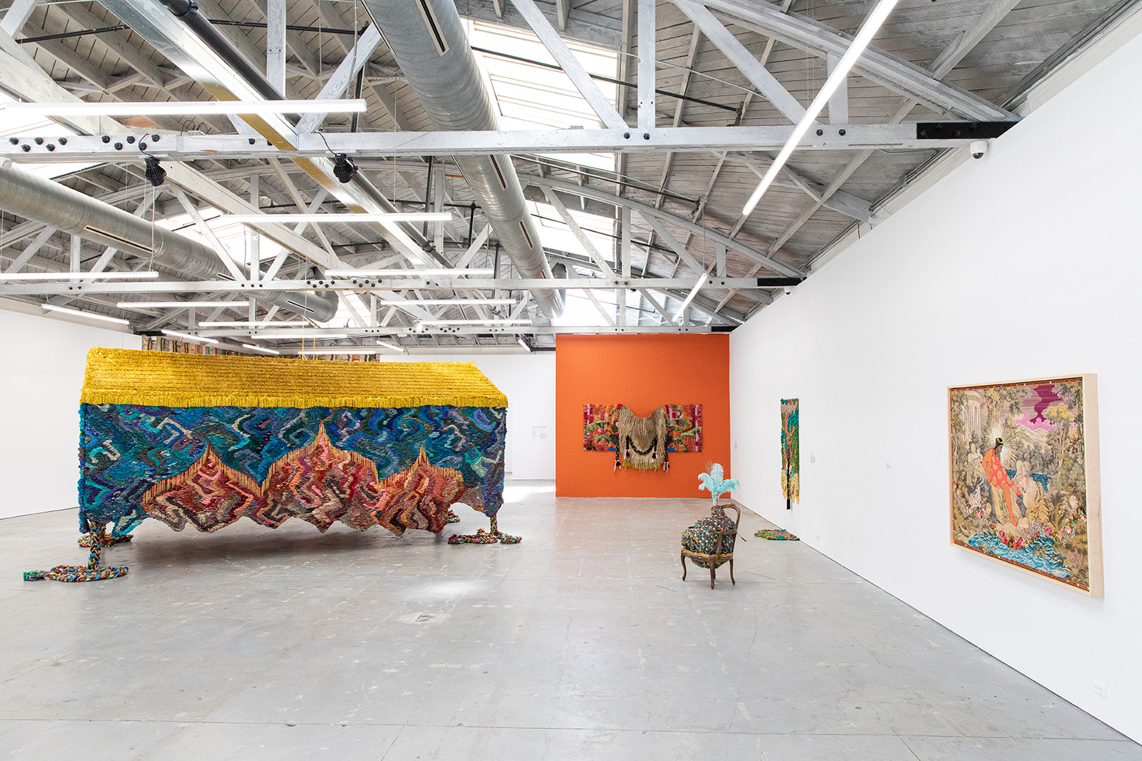 Colorful art sits in a white gallery space.