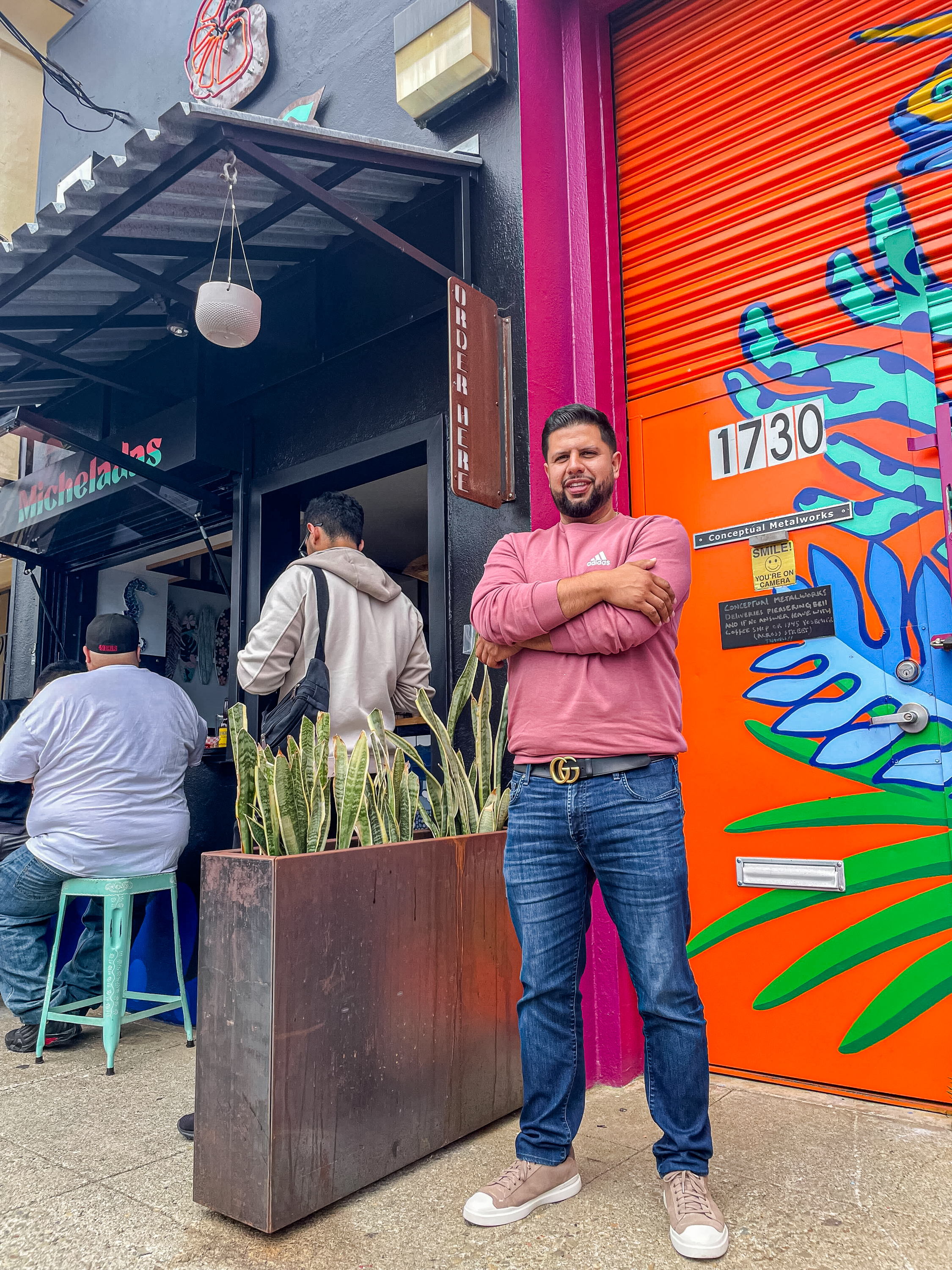 A man in front of a restaurant.