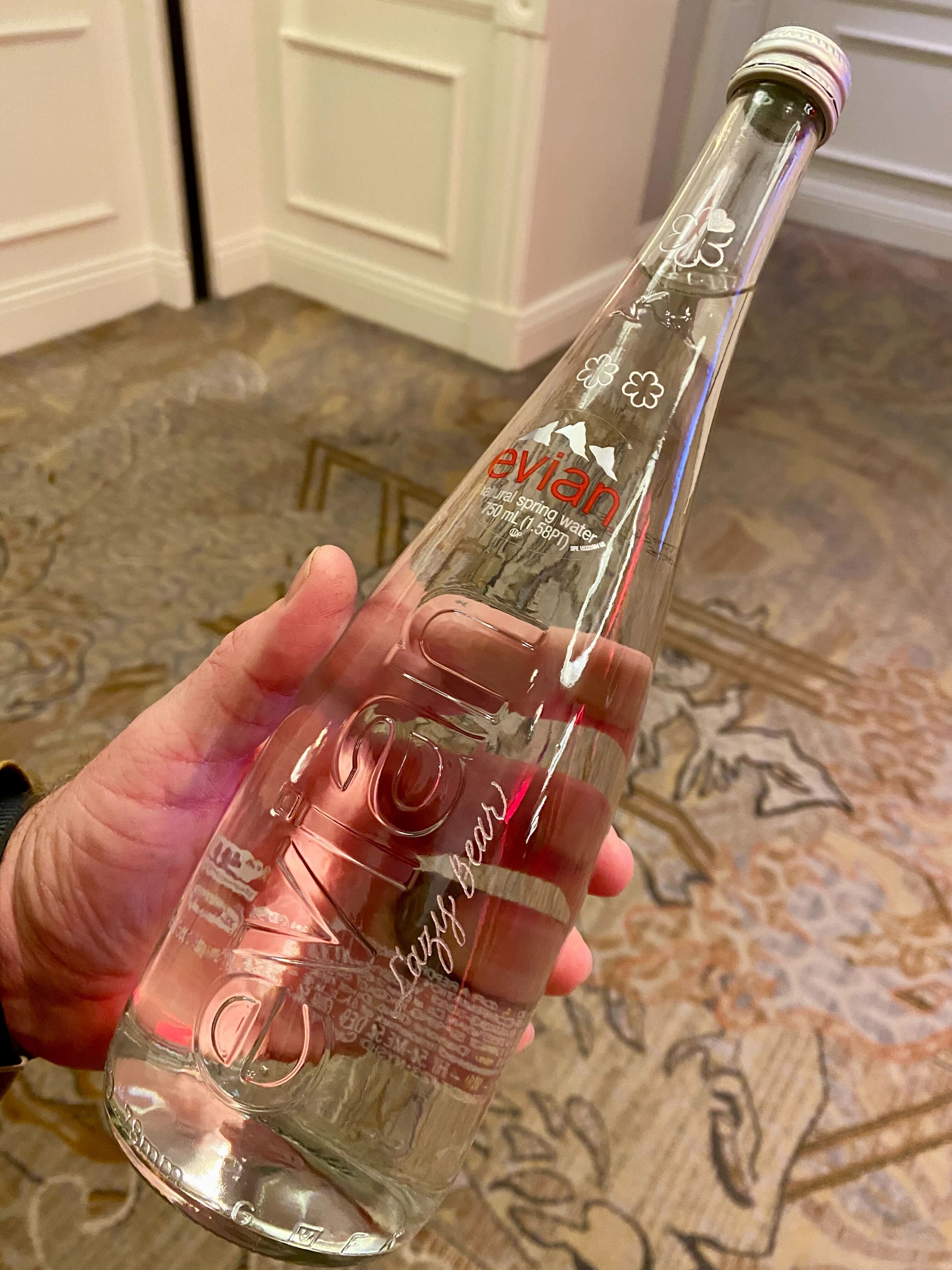 A glass bottle of Evian water engraved with the words &quot;Lazy Bear&quot; and two stars.