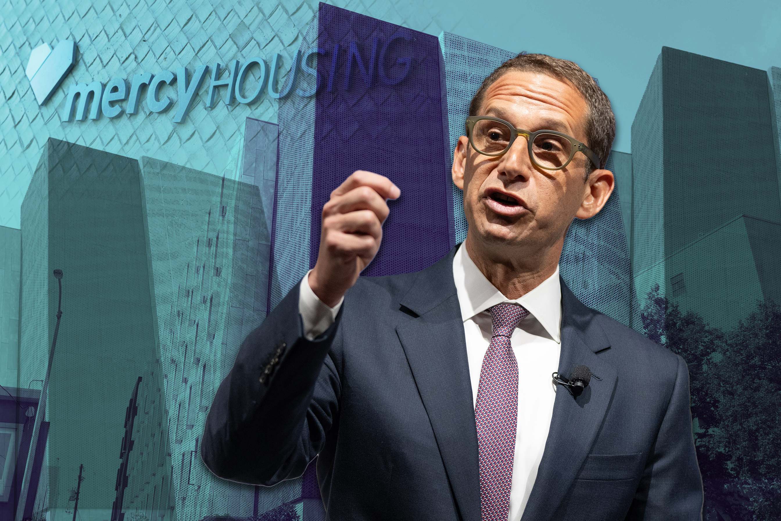 A man in a suit and tie speaks passionately with a raised hand. Behind him is a building with the words "mercy HOUSING" on its facade.