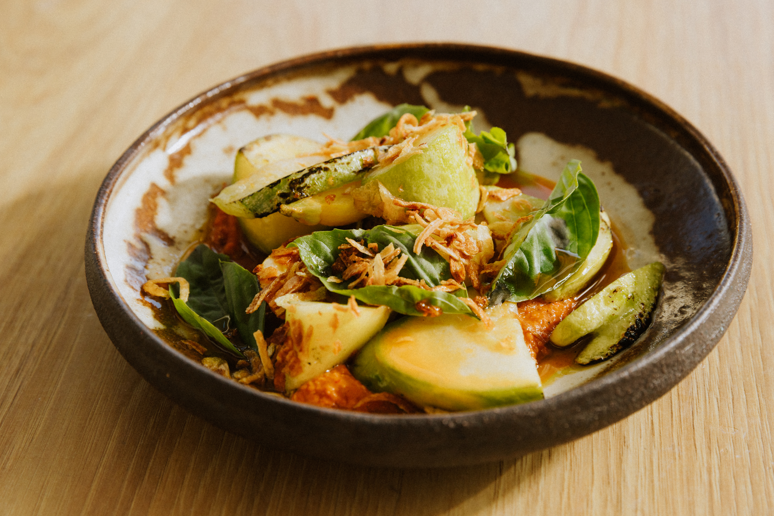 A seasonal summer squash dish at Kothai Republic in San Francisco. The dish is made with organic farm squash, aged kimchi romesco, and butter beans.