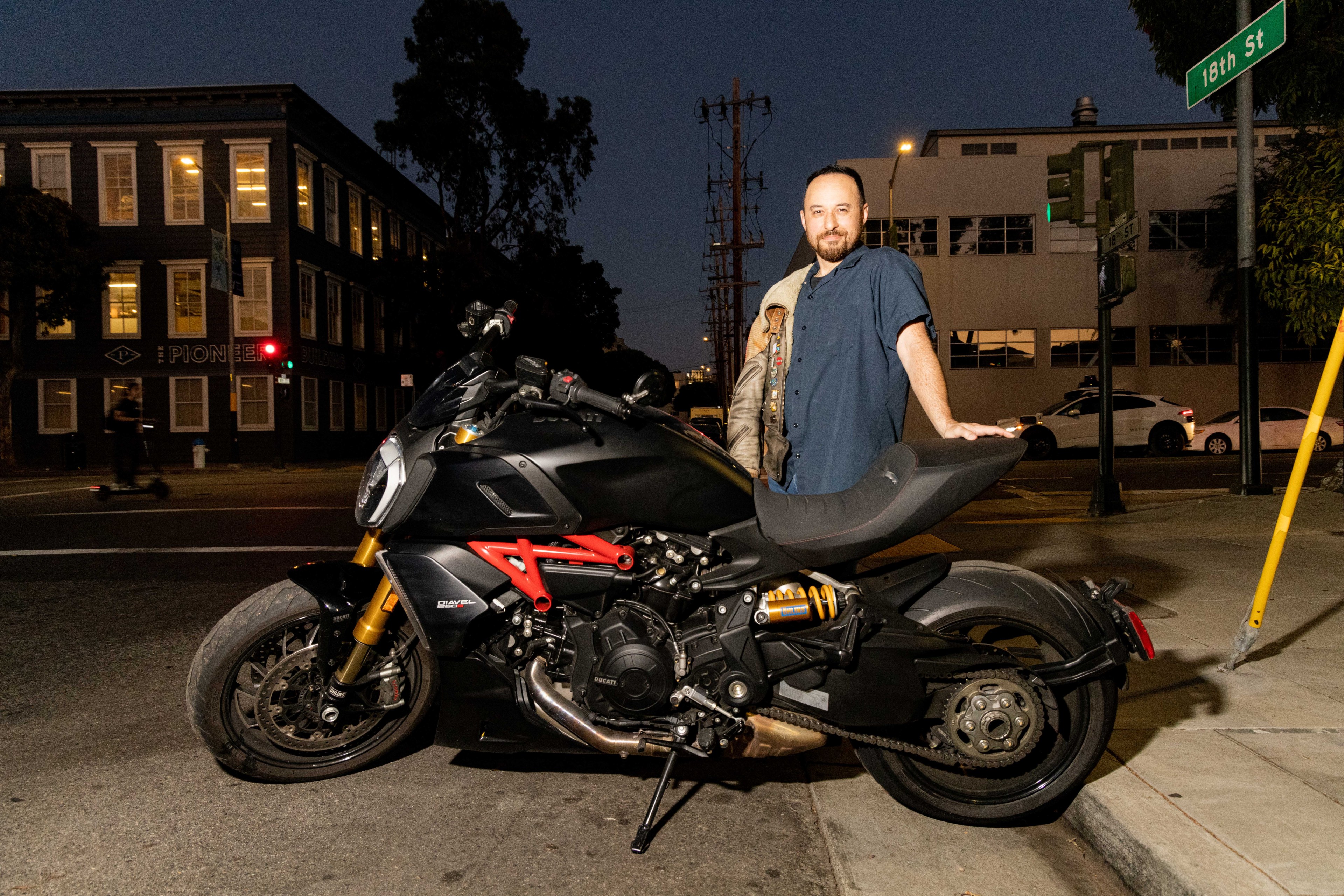 A man poses with his motorcycle.