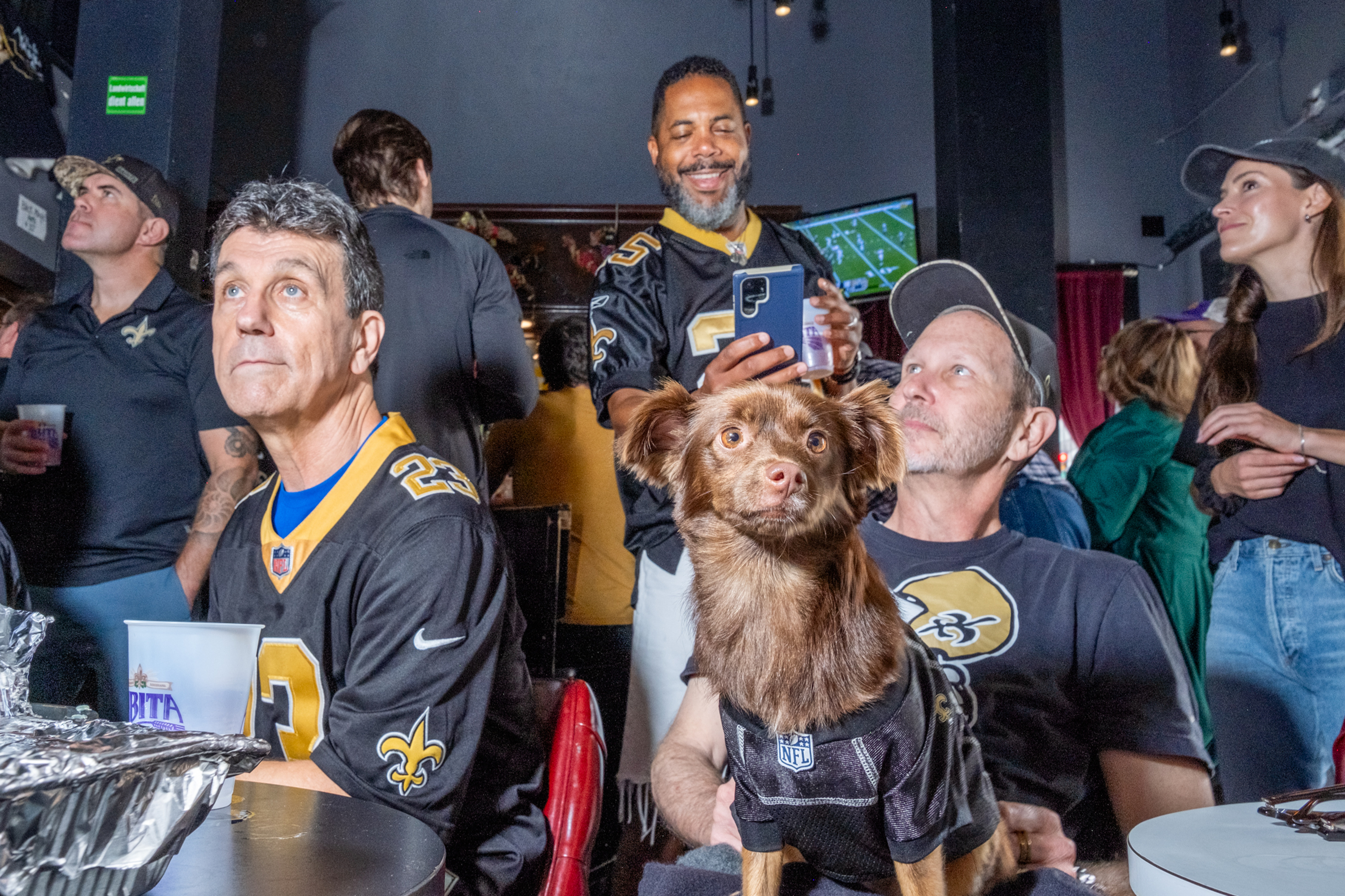 Crowds and one dog named Ivy, watch the Saint’s play football from the Black Magic Voodoo Lounge  on Van Ness Ave. of San Francisco on Sunday, Oct. 13, 2024. David Lombardi, known for his coverage of the 49er’s, knows the best joints in town to get your football on.