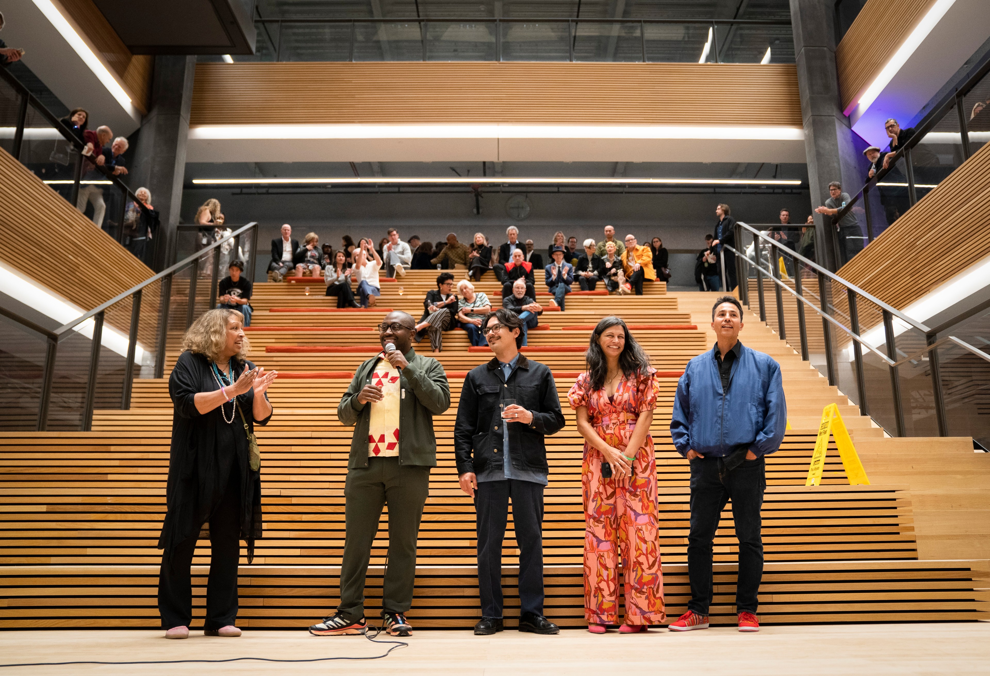 Five people stand at the bottom of cantilever stairs.