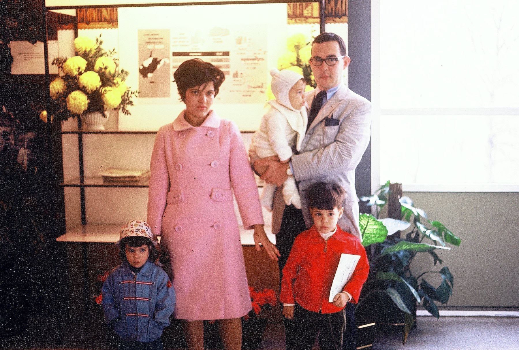 A family of three children and two adults poses in a store front.