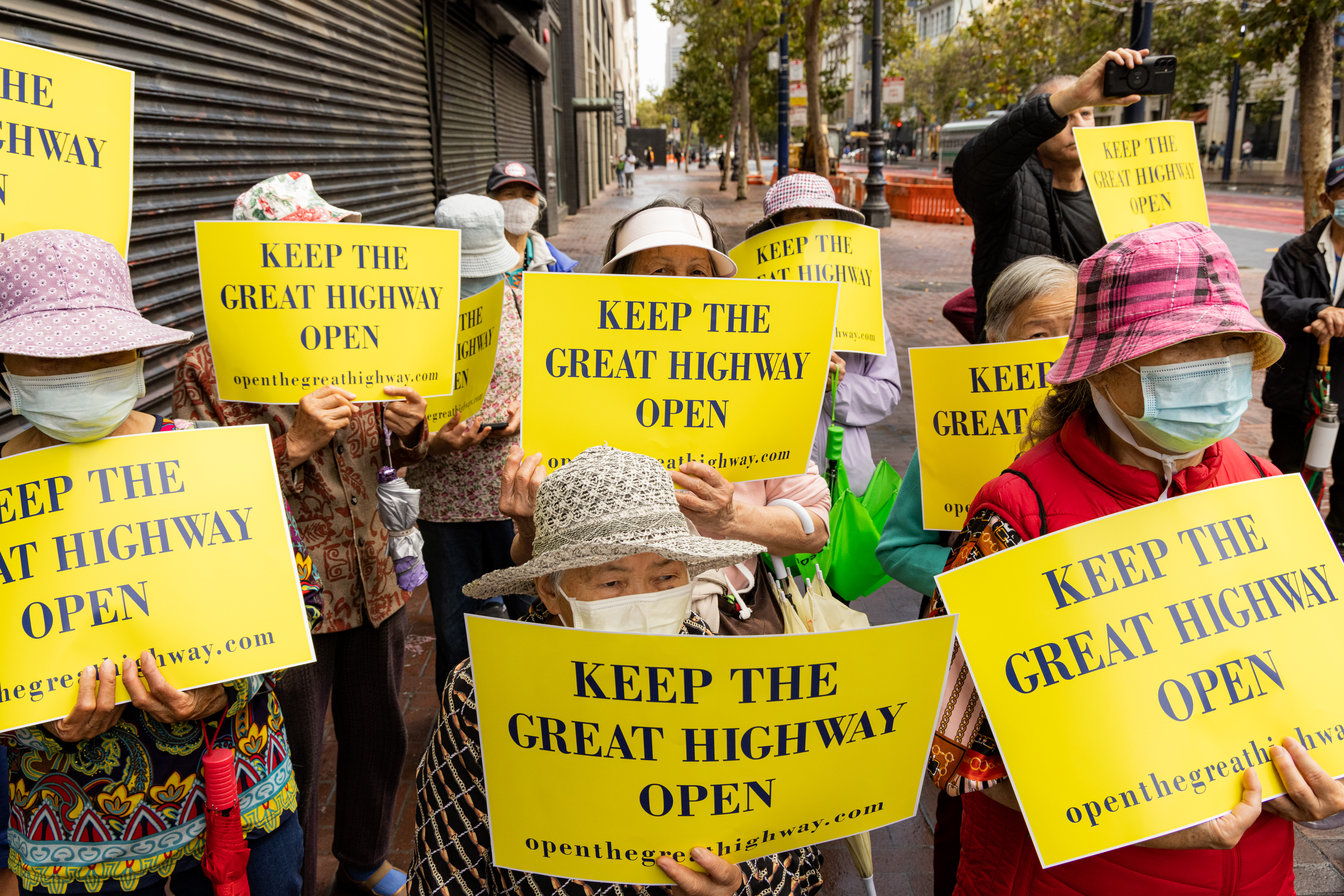 People held signs at a ÒKeep The Great Highway OpenÓ rally held on Market and Hyde Streets before a car rally drove around the city on August 24, 2024. The Chinese American Democratic Club held a rally on Market and Hyde streets against proposition K, which would close The Great Highway. About 30 people showed up for the rally and about 10 cars participated in the car rally.