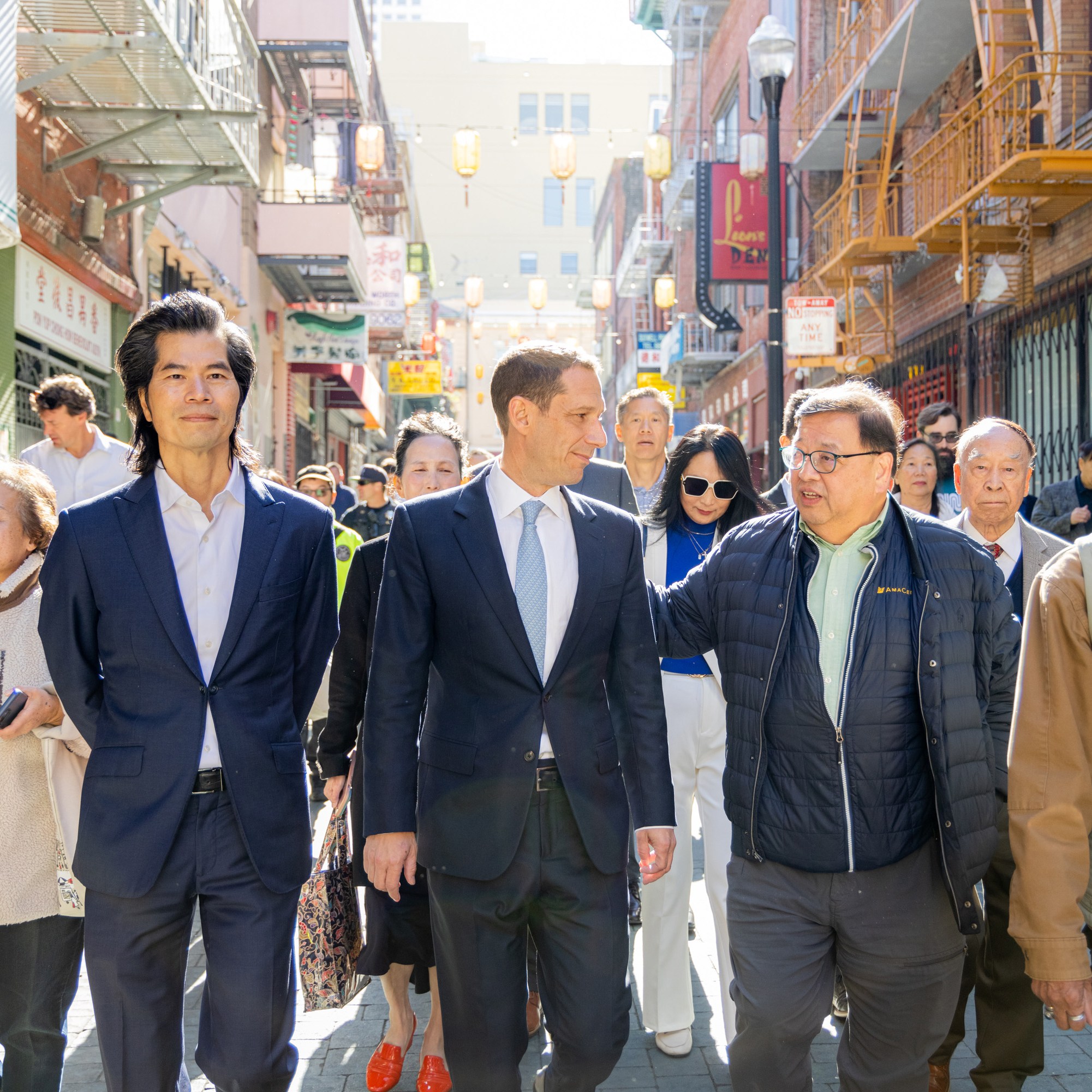 A man walking with a group of people down a busy street.