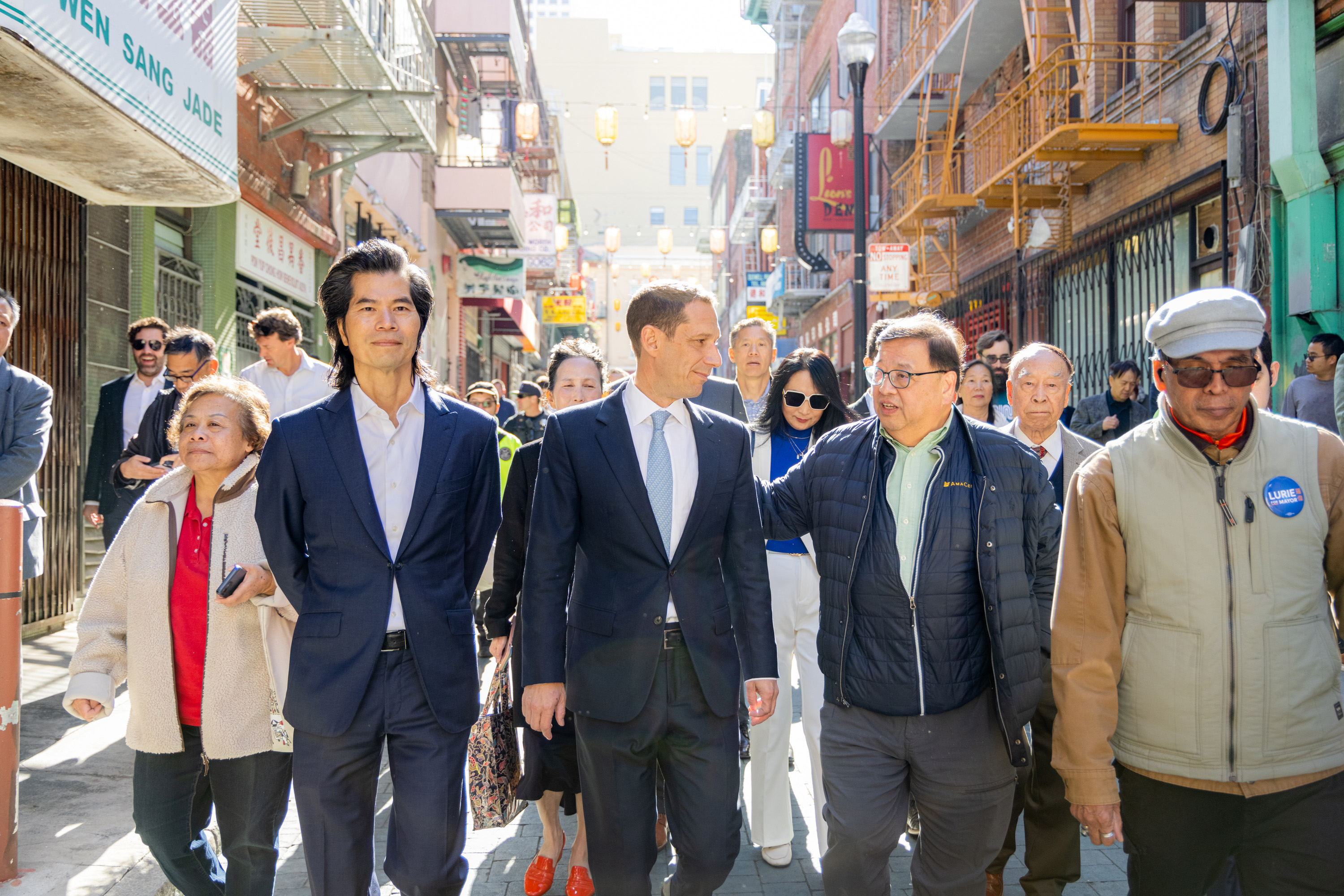 A man walking with a group of people down a busy street.