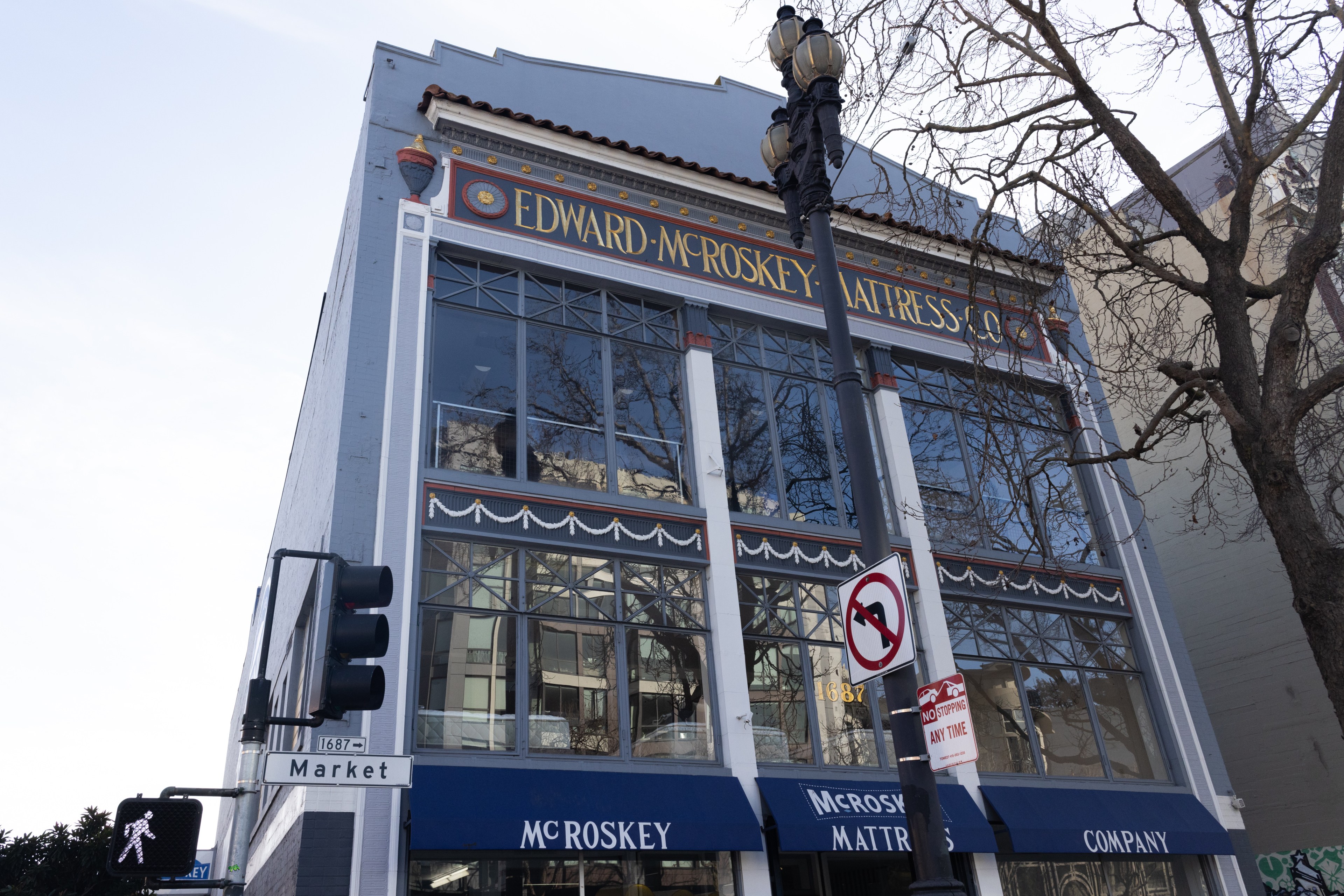 The image shows a building with a sign reading &quot;Edward McRoskey Mattress Co.&quot; It's on a street corner marked &quot;Market&quot; with traffic lights and a no left turn sign.