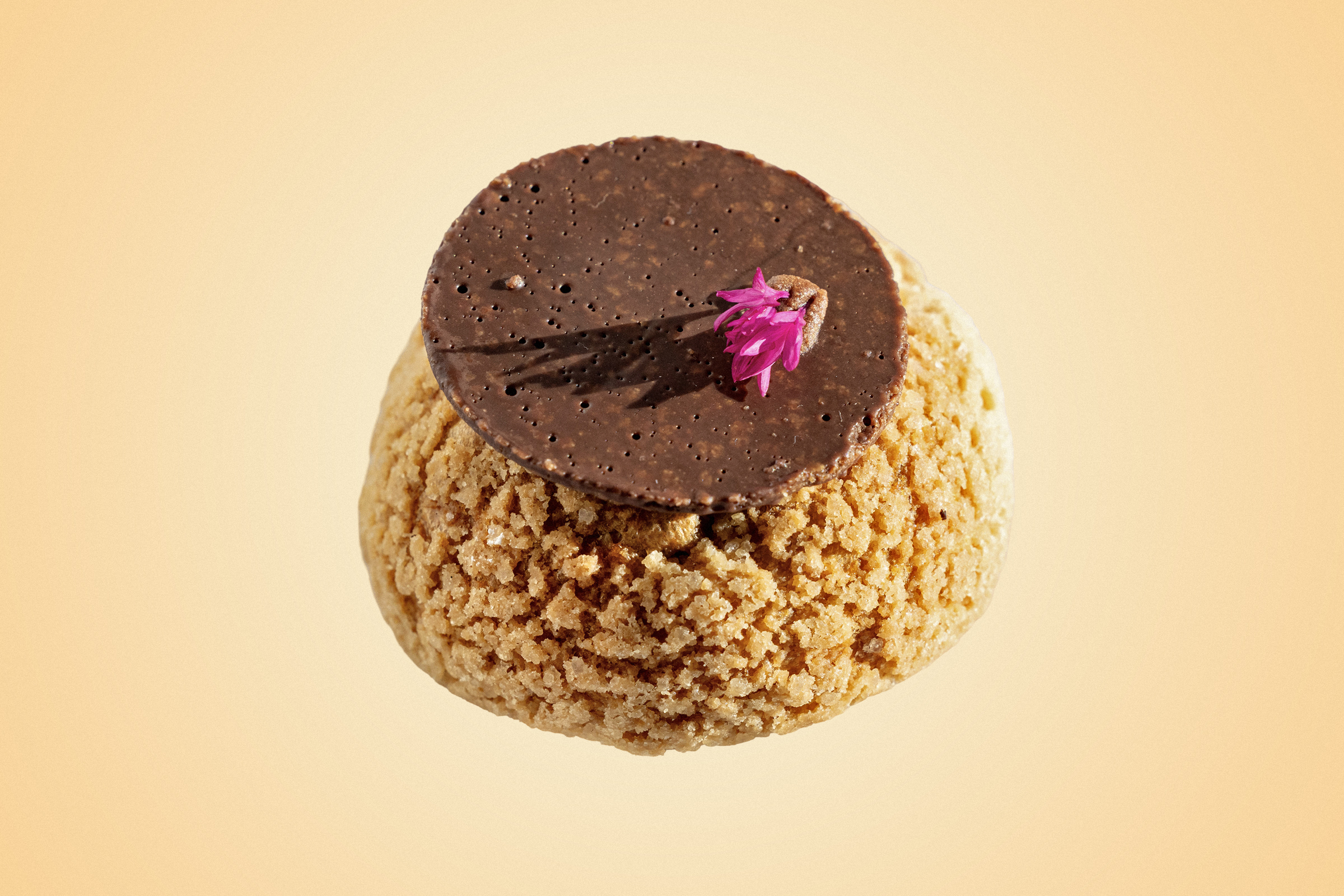 A pastry bun with a decorative chocolate and flower.