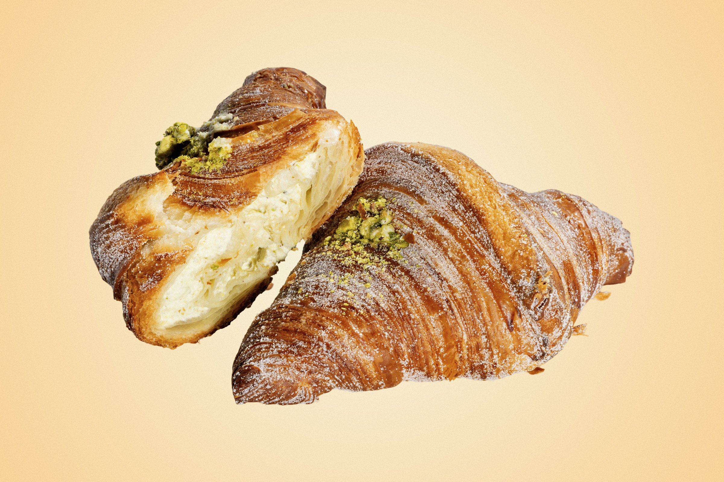 Two croissants topped with nuts and sugar.