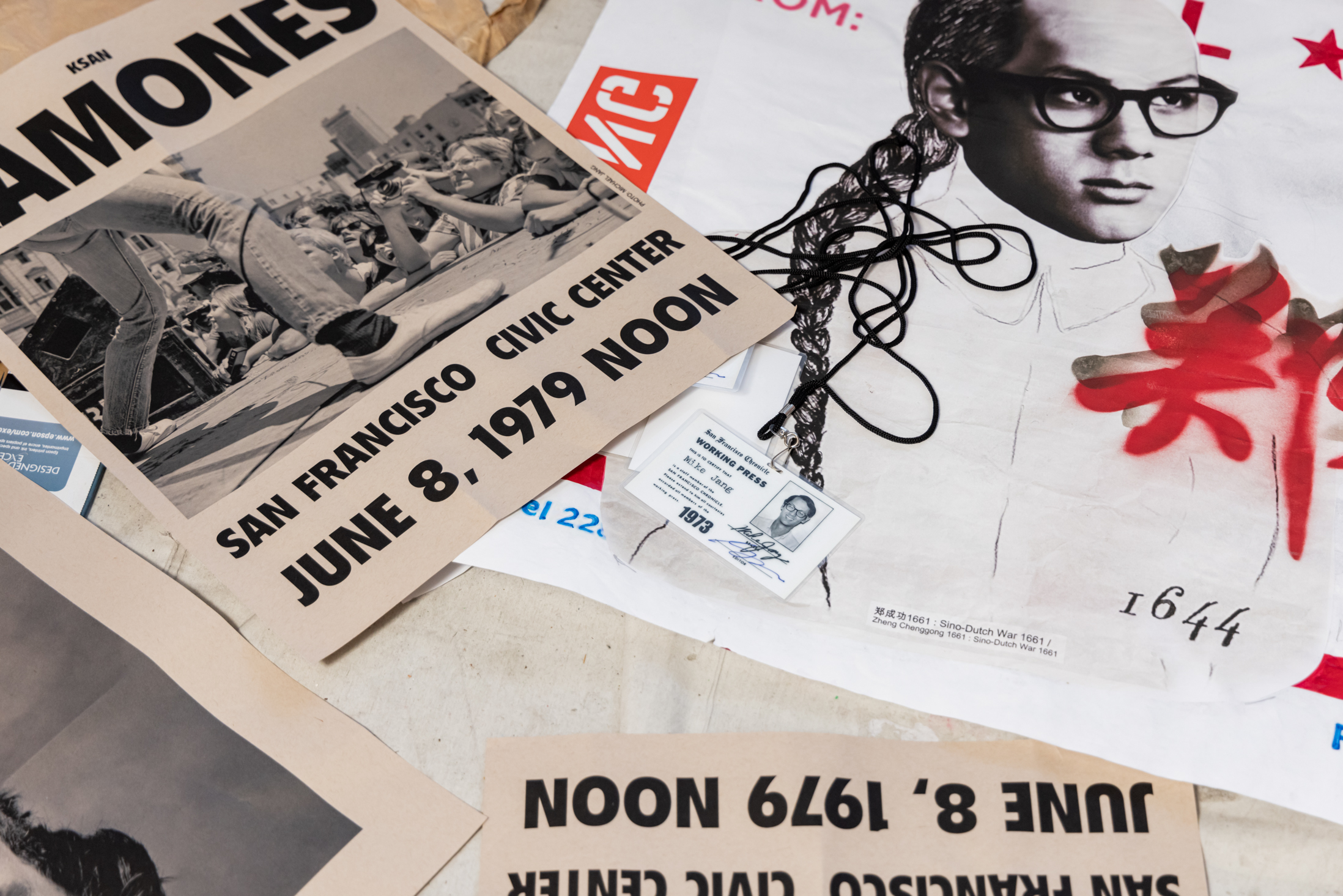 The image shows a black-and-white Ramones concert poster dated June 8, 1979, at San Francisco Civic Center, alongside a poster featuring a man with glasses and a press pass.