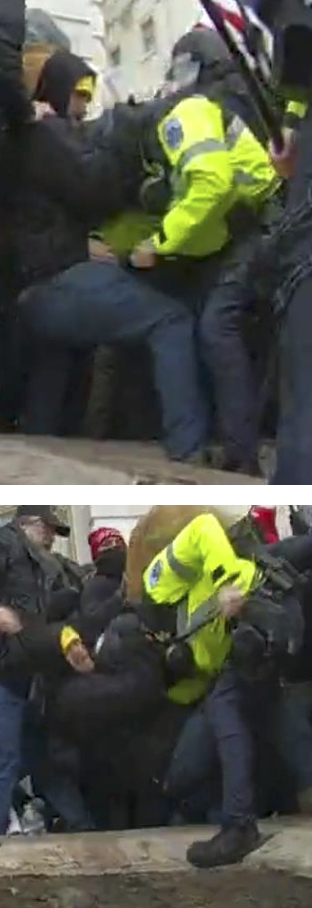 A police officer in a bright yellow jacket is struggling with a crowd of people, who appear to be engaged in a chaotic confrontation.