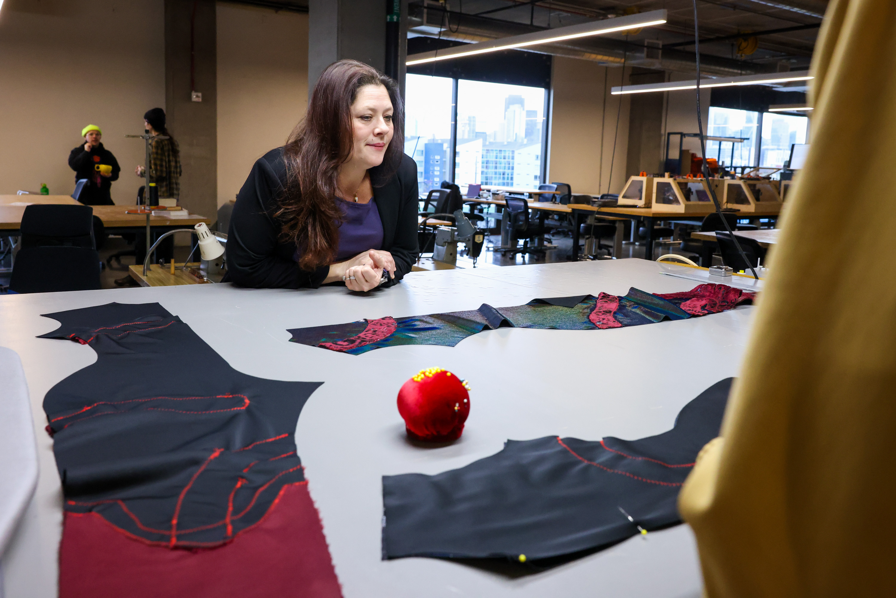 Sandra Spurlock talks with a student pinning cut-out fabric on a worktable at nonprofit Humanmade’s San Francisco facility.