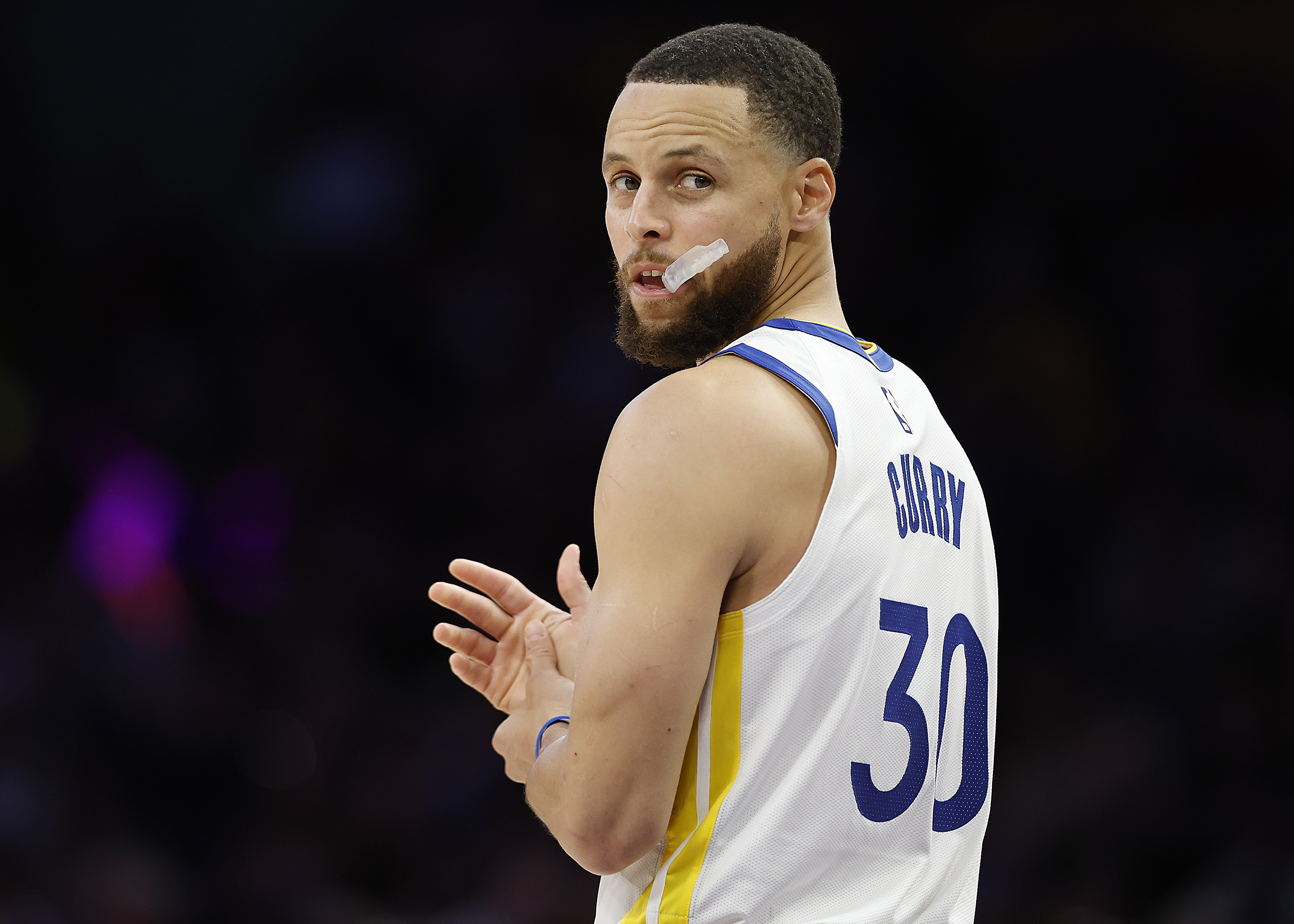 A basketball player chewing on his mouth guard