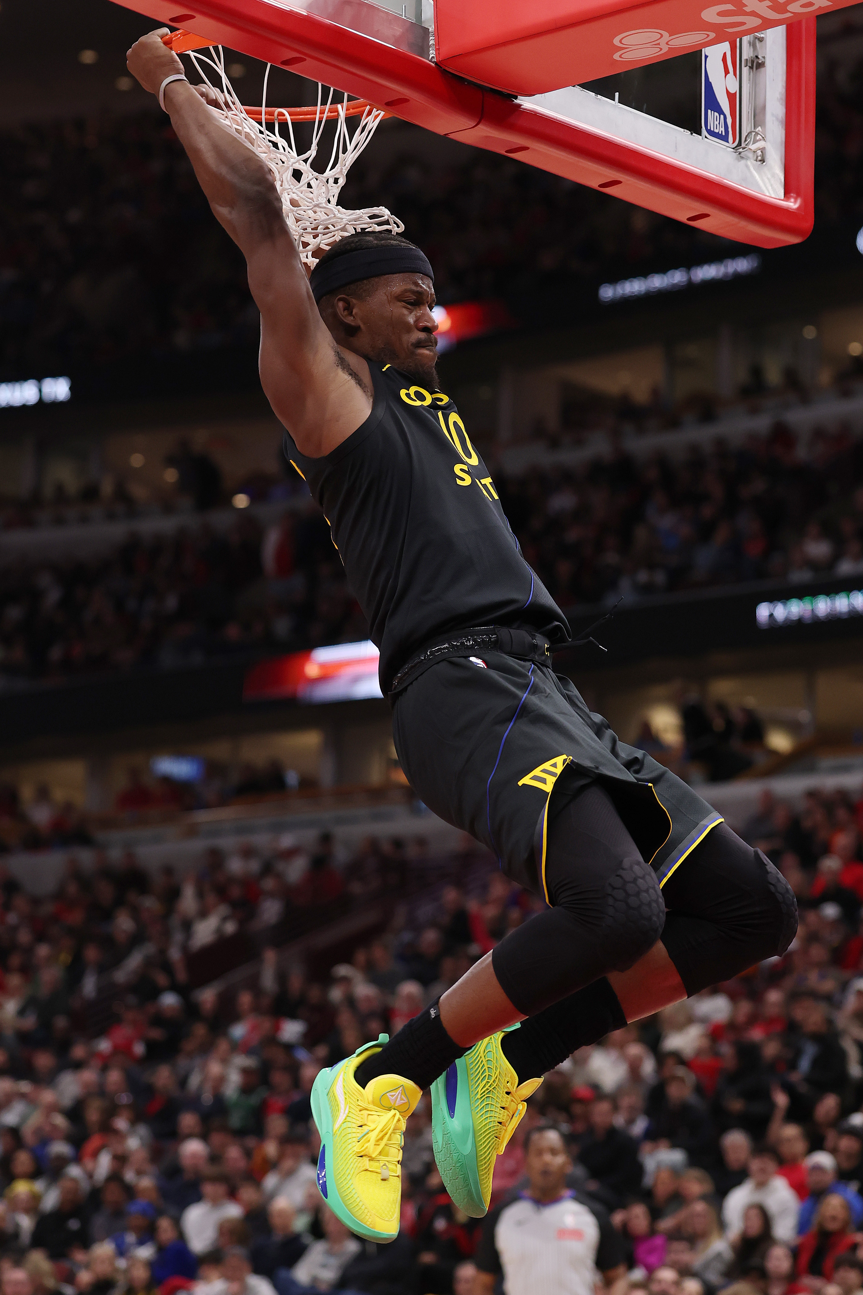 A basketball player balancing on a hoop