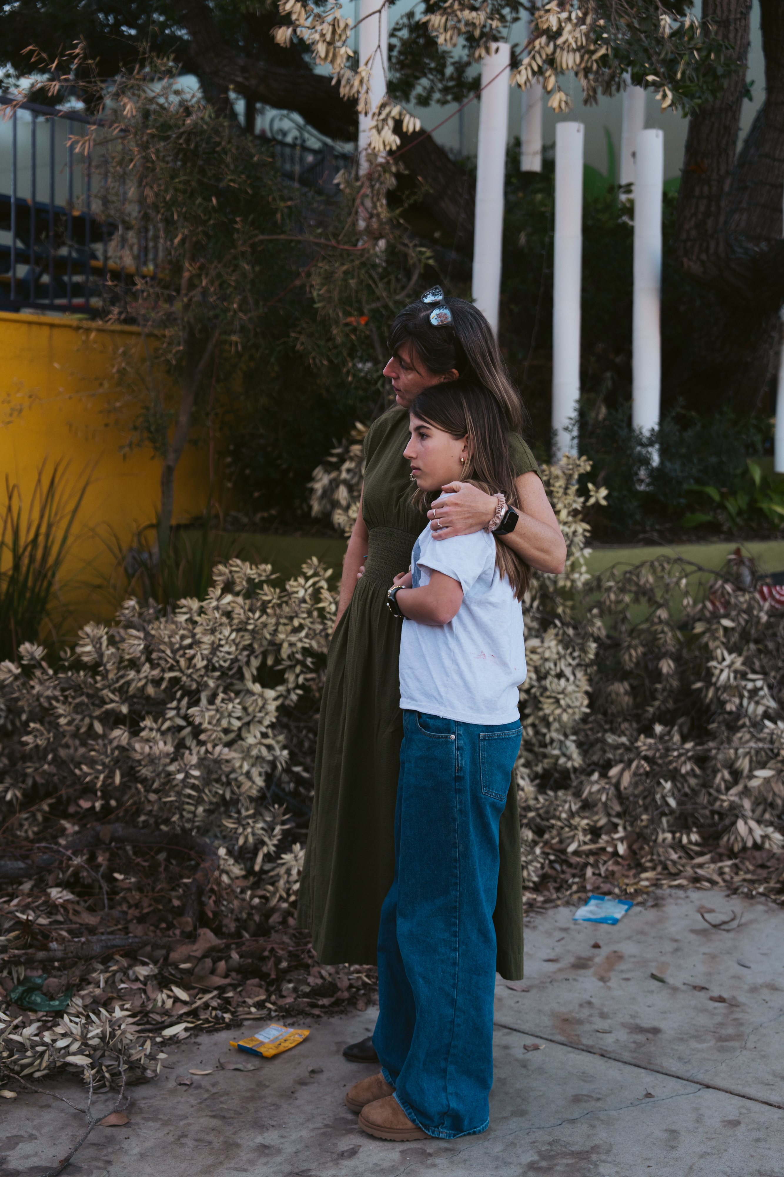 Samantha Wiesler hugs her daughter Evening as they witness Village School’s burned down campus in Pacific Palisades in Los Angeles on Thursday, Feb. 20, 2025.