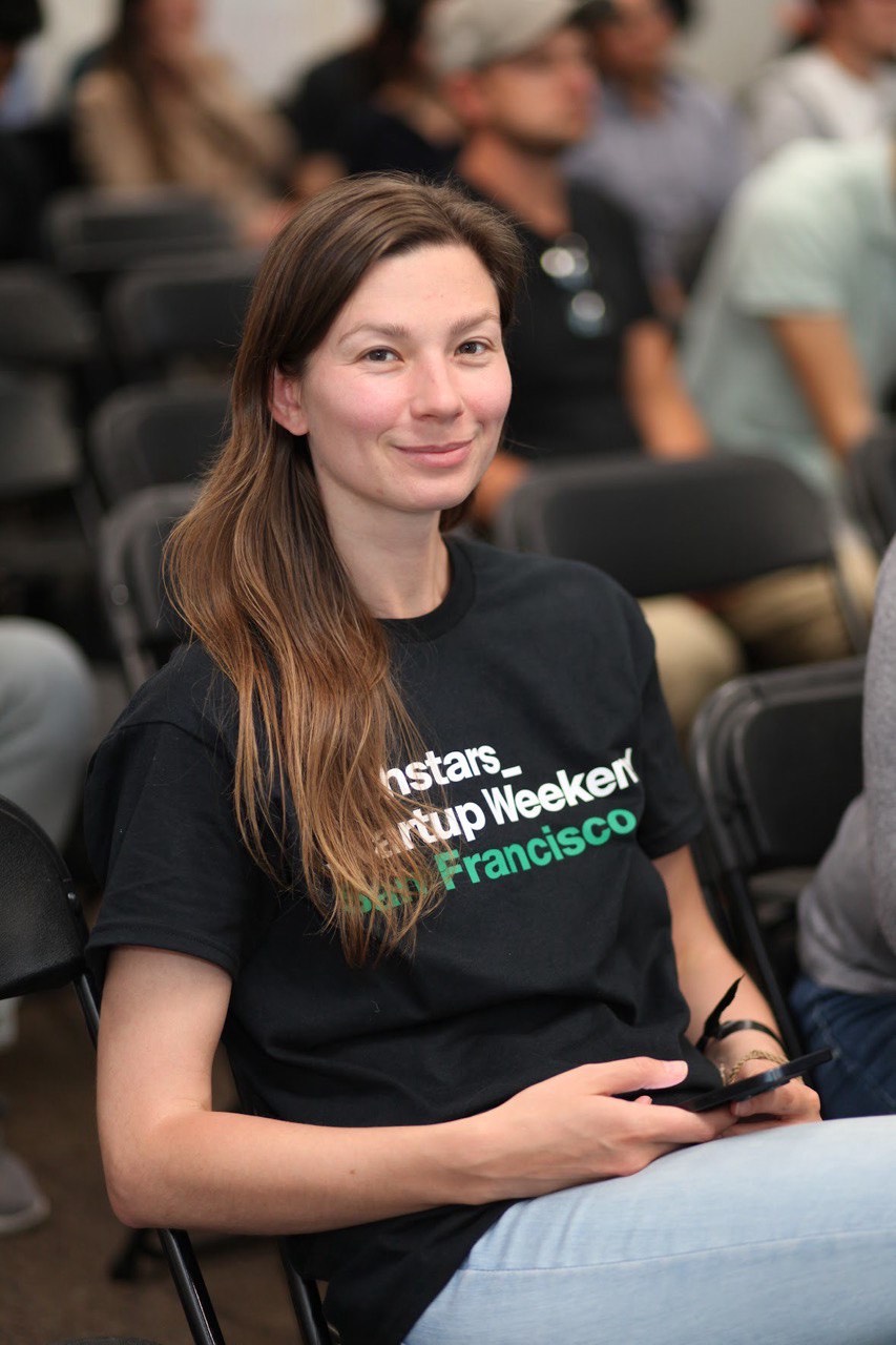 A woman in a black shirt smiling at the camera.