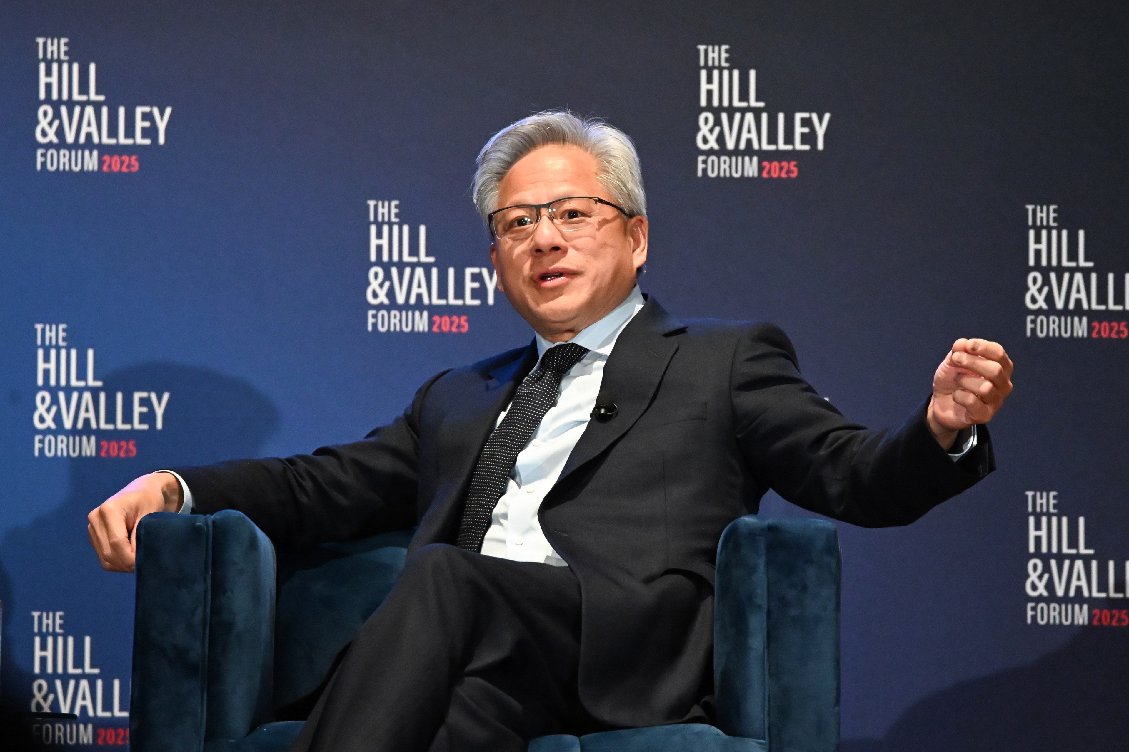 A man in a black suit and glasses is speaking, seated in a blue chair against a backdrop that says &quot;The Hill &amp; Valley Forum 2025&quot; in white text.