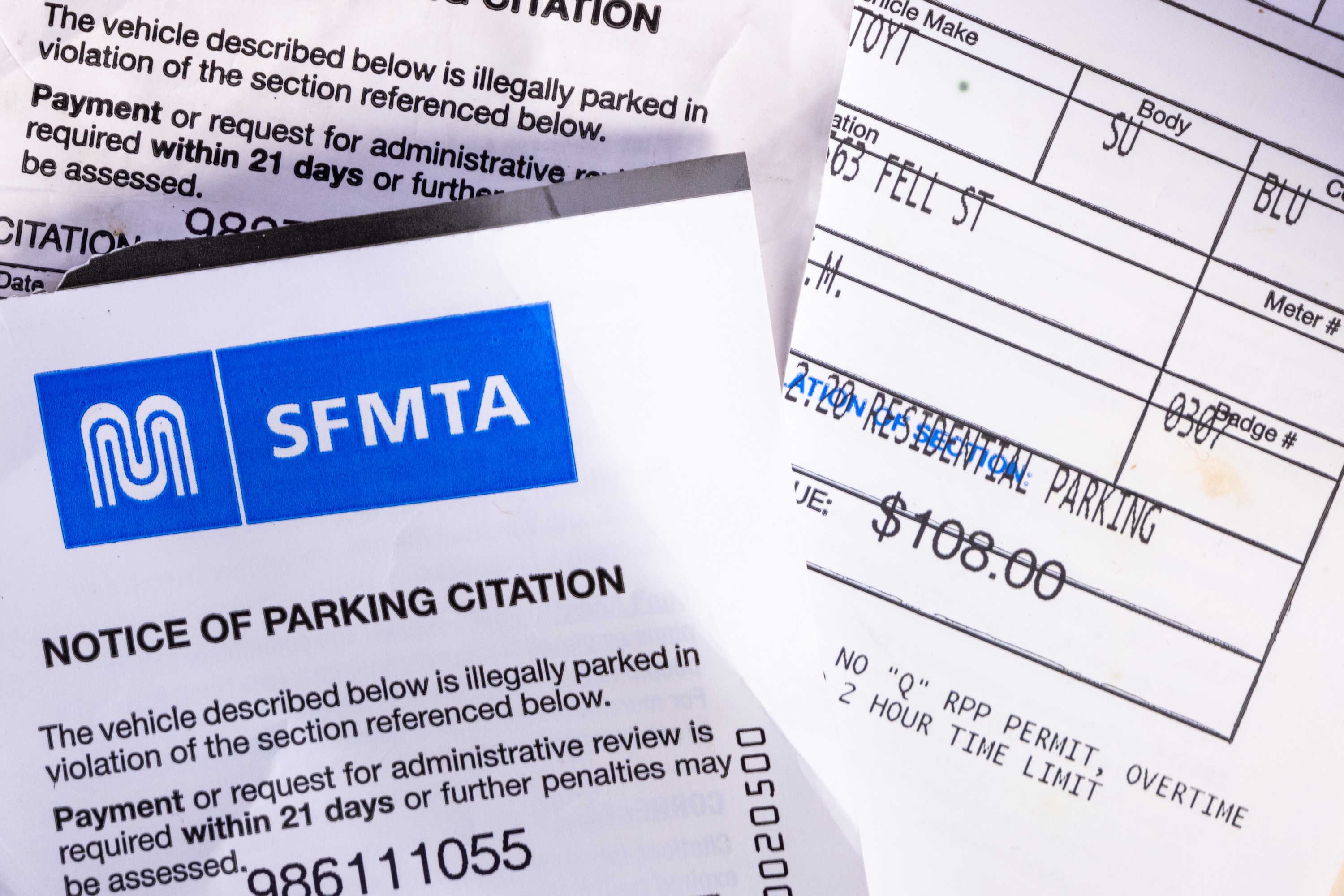 This image shows an SFMTA parking citation notice with details about a parking violation, including the fine amount of $108.00.