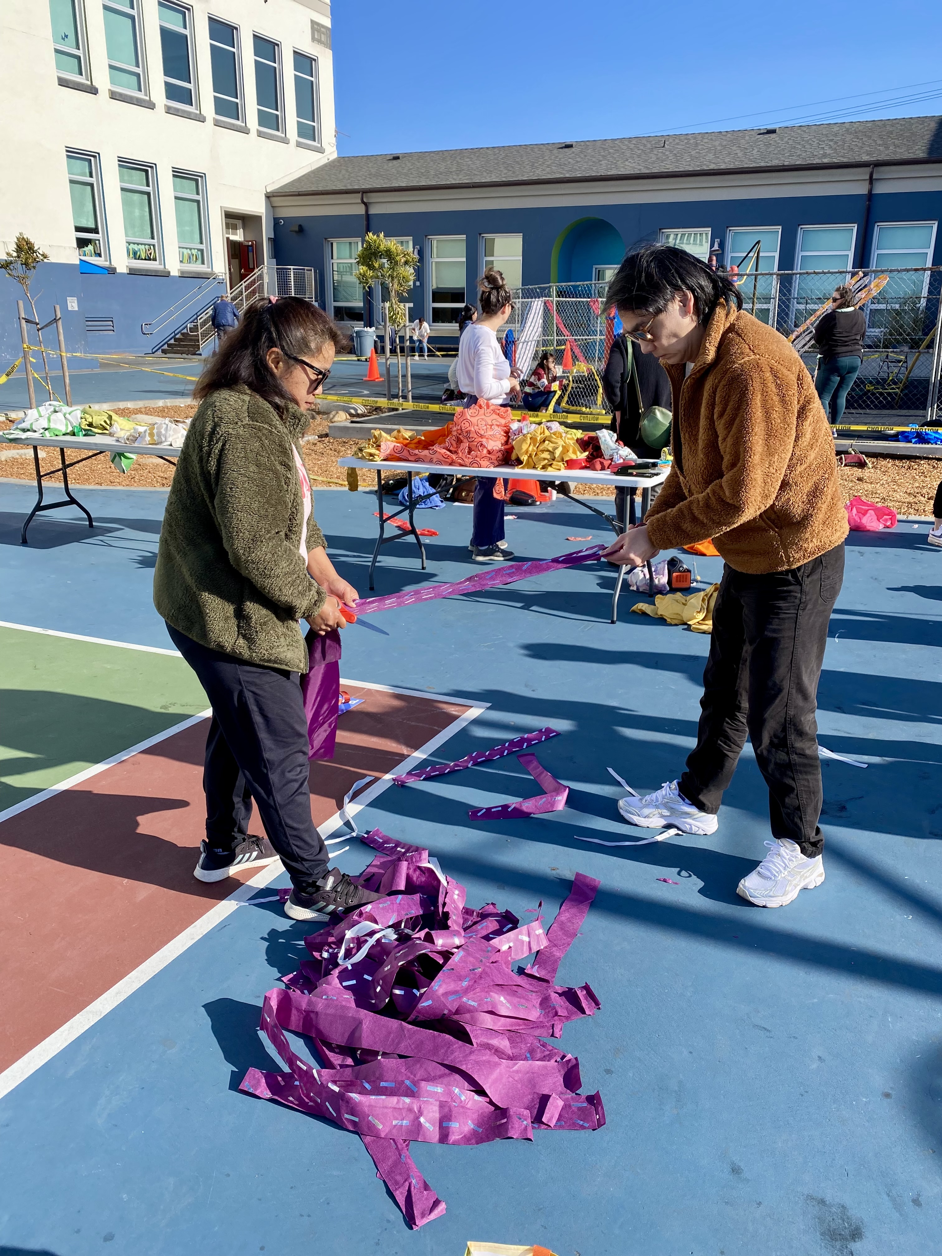 A photo of community members decorating a fence.