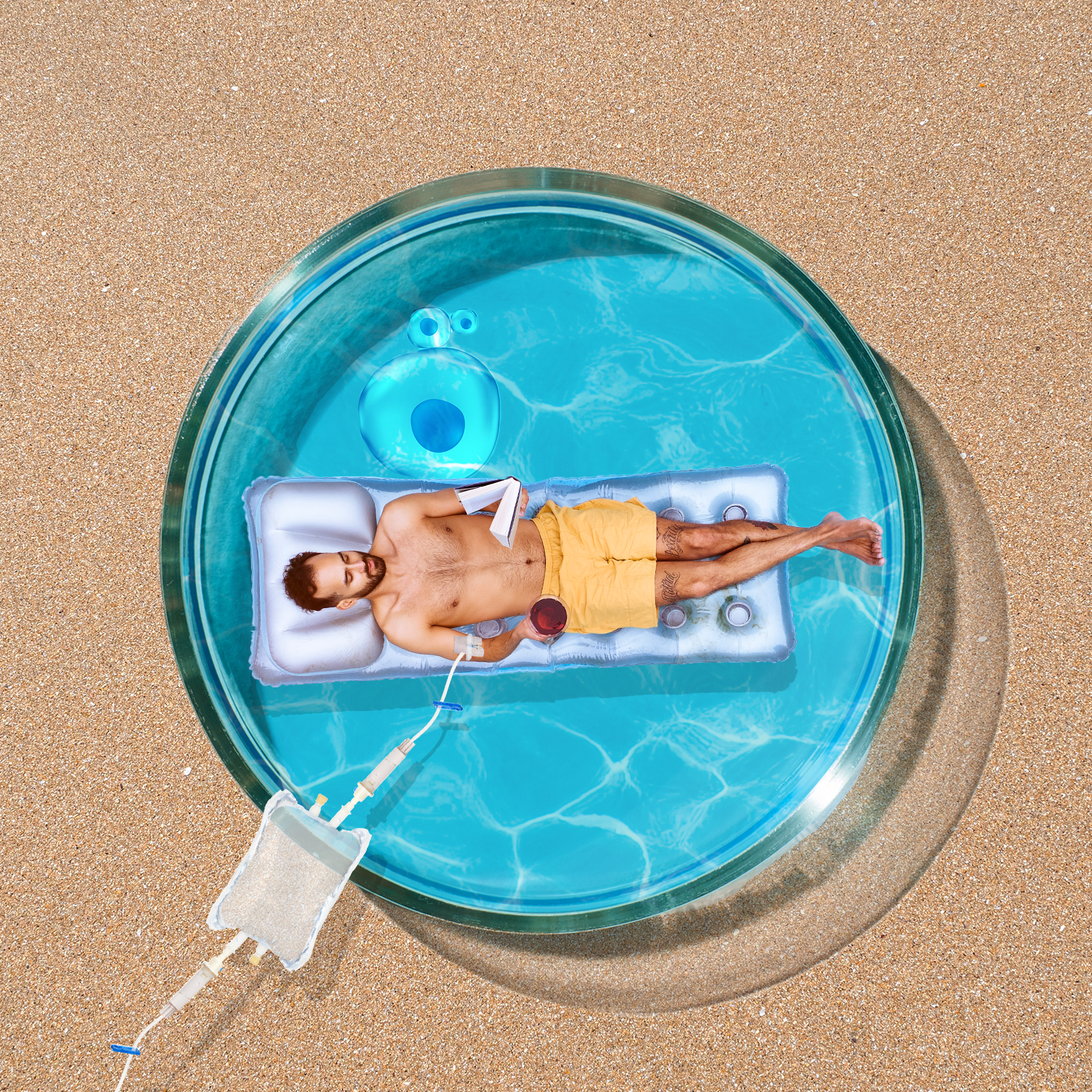 A man relaxes on an inflatable in a small, circular pool on a sandy surface. He holds a drink and a book, wearing yellow shorts under a clear, sunny sky.