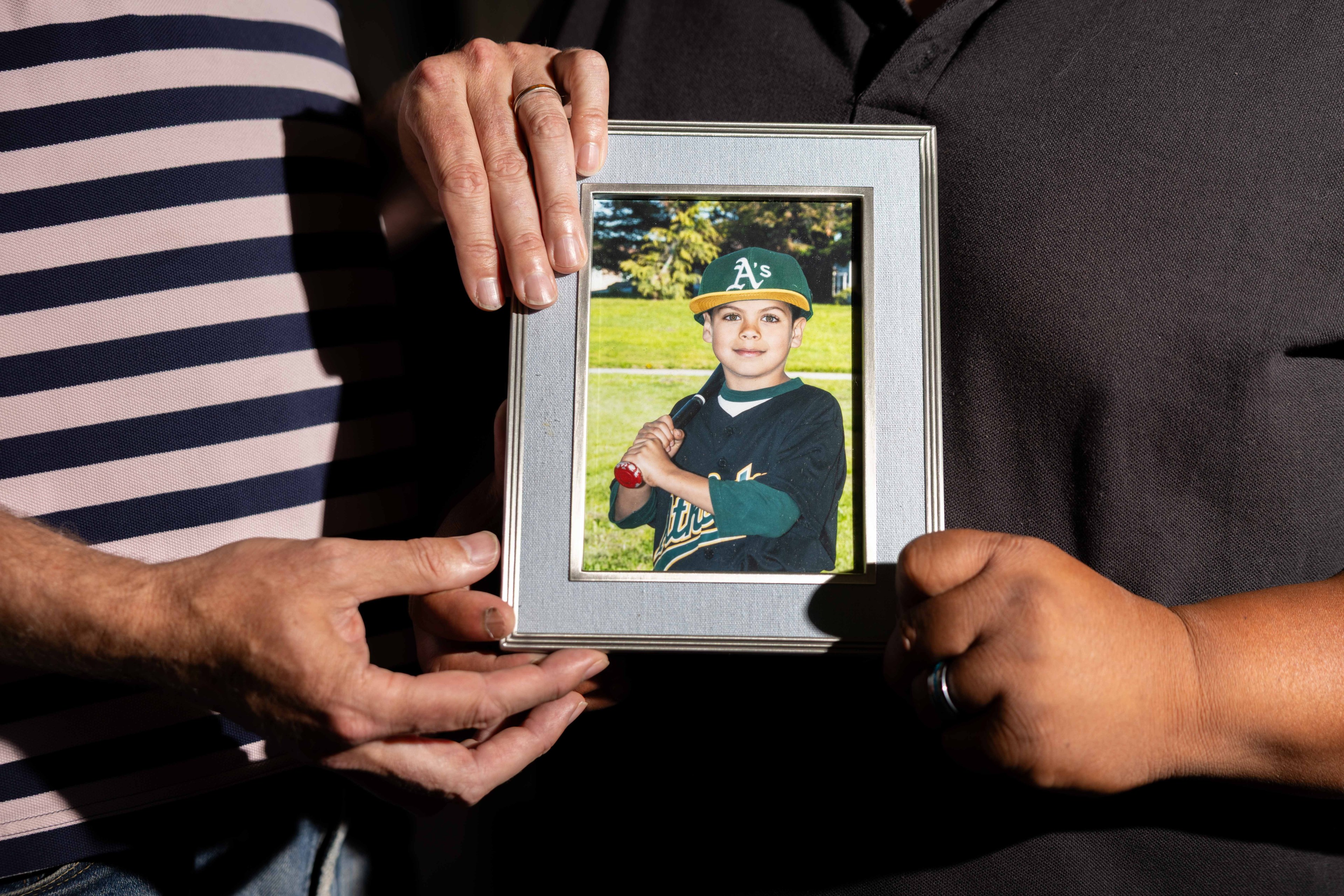 Degala and Burnett hold photo of Caleb as child